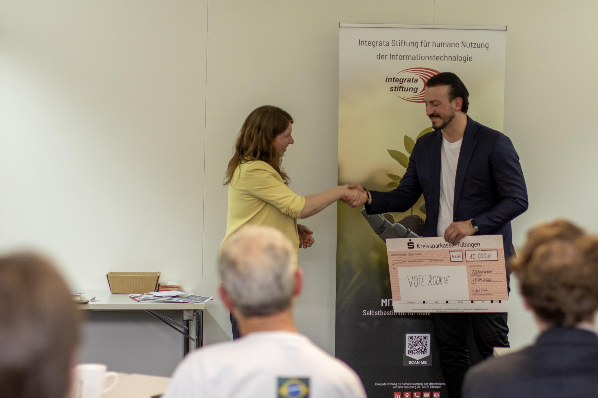 Anna Christmann überreicht David Gelantia den Preisscheck